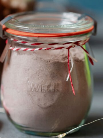 glass jar of hot cocoa mix with ribbon.