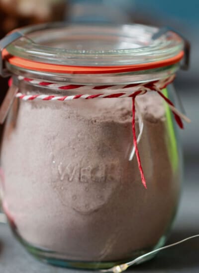 glass jar of hot cocoa mix with ribbon.