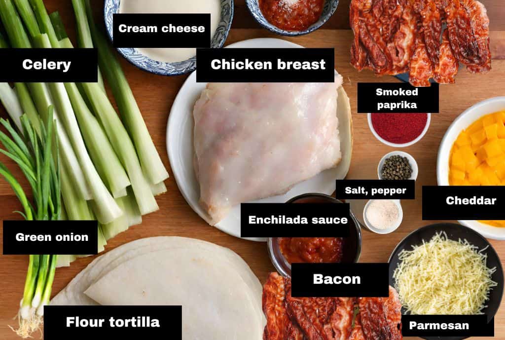 all ingredients for chicken tortilla roll ups arranged on wooden board.