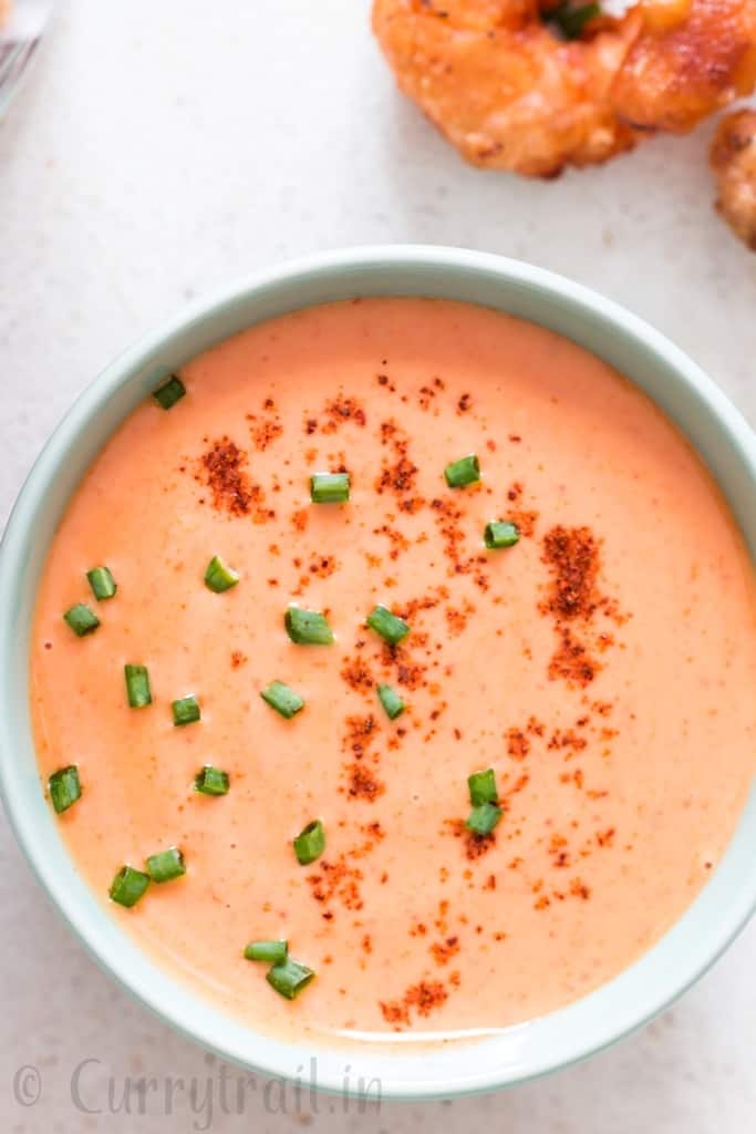 bang bang shrimp sauce in bowl with fried shrimps on side