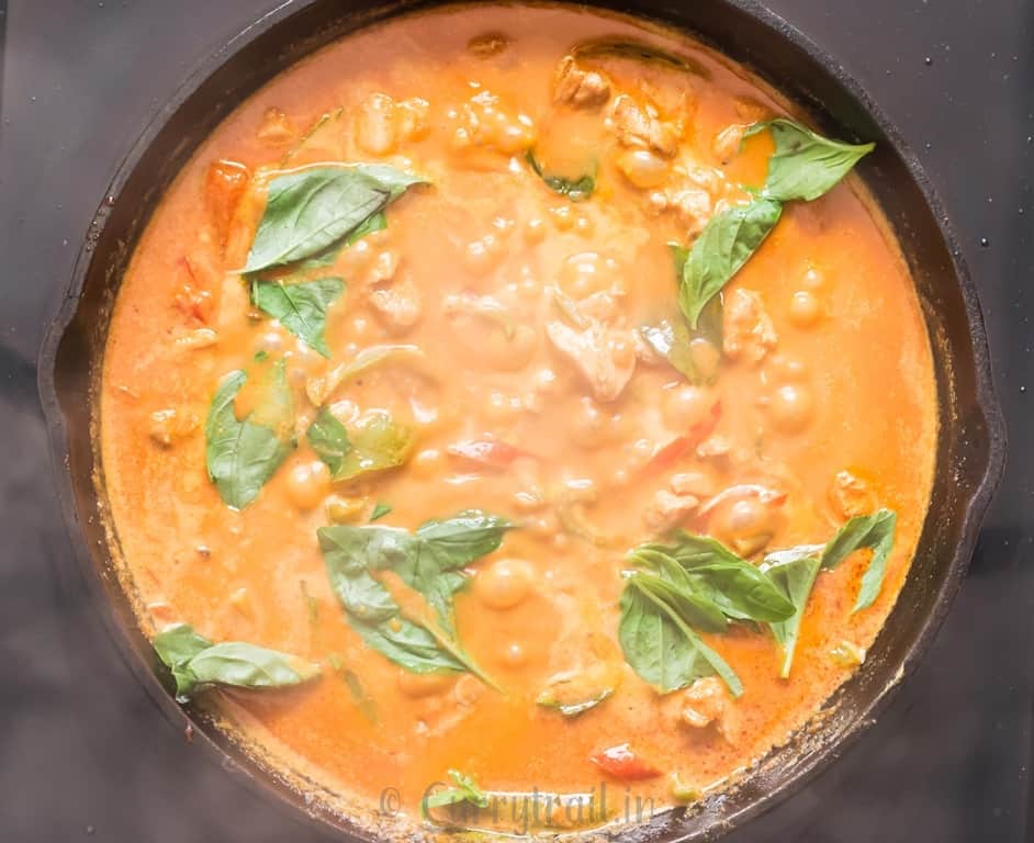 best Thai chicken Panang curry topped with fresh basil cooked in cast iron pan