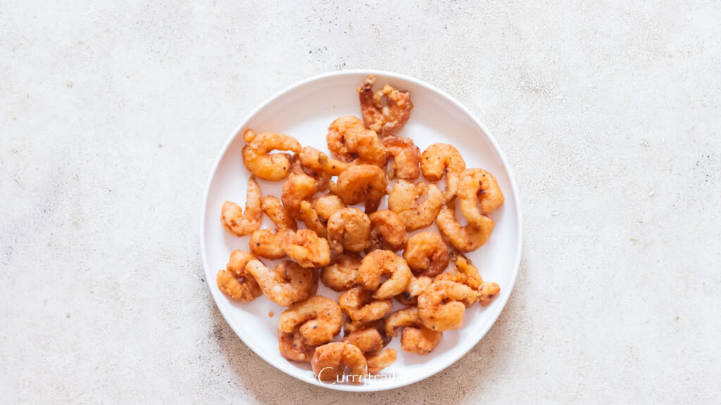 crispy, crunchy deep-fried shrimp on a white plate.