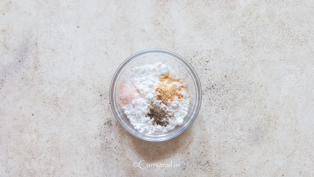 cornstarch mixed with garlic powder, salt, and pepper in a bowl.