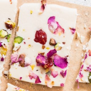 white chocolate bark with dried rose petals, pistachios and dried strawberries on parchment paper