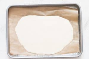 melted white chocolate spread on parchment paper for white chocolate bark