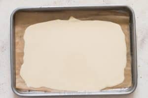 melted white chocolate spread on parchment paper for white chocolate bark