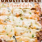 cheesy cauliflower breadsticks on baking tray with text