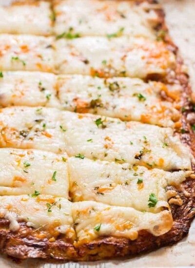 cheesy cauliflower breadsticks served with spicy marinara sauce