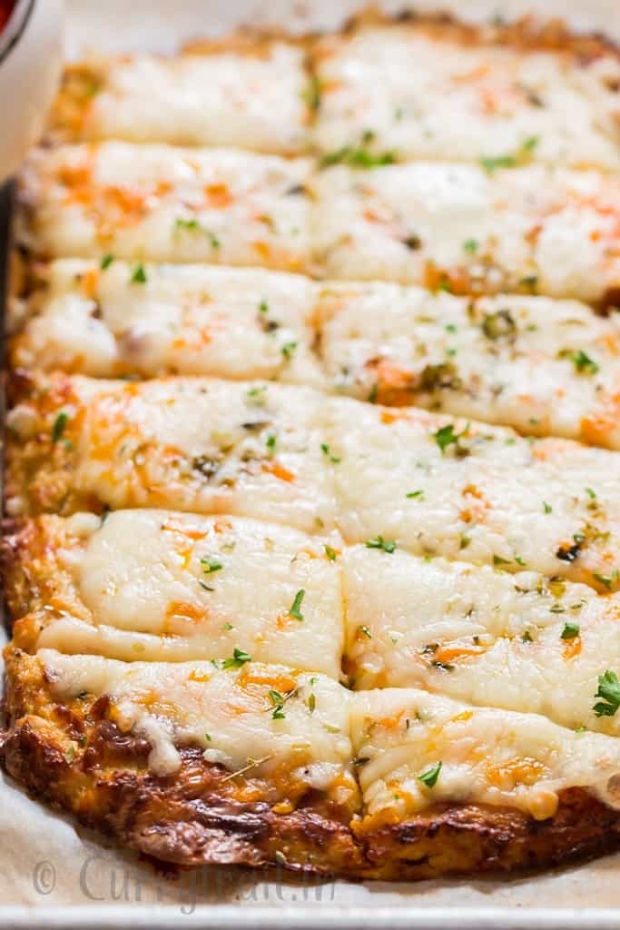 freshly baked cheesy cauliflower breadsticks on baking tray