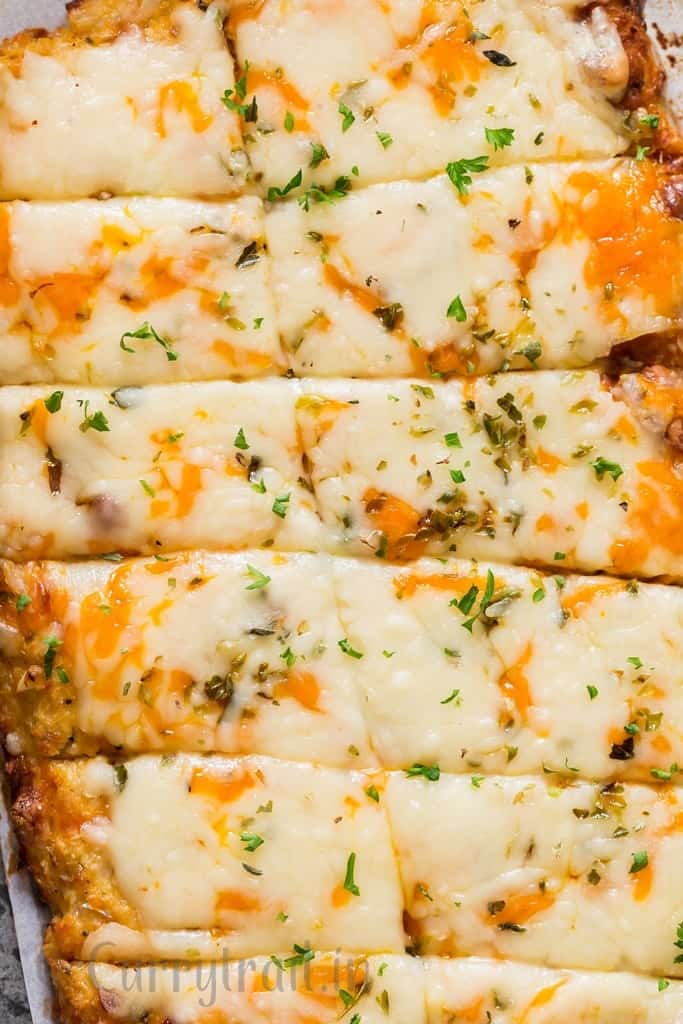 close up of cheesy low carb breadsticks on baking tray