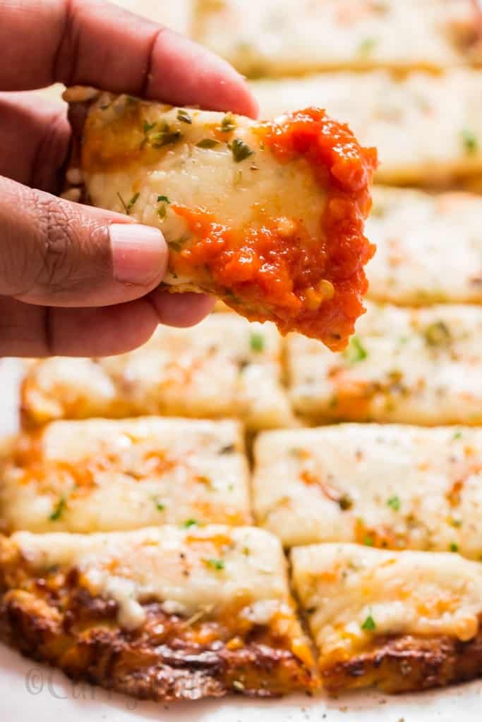 cheesy cauliflower breadsticks dipped in spicy marinara sauce