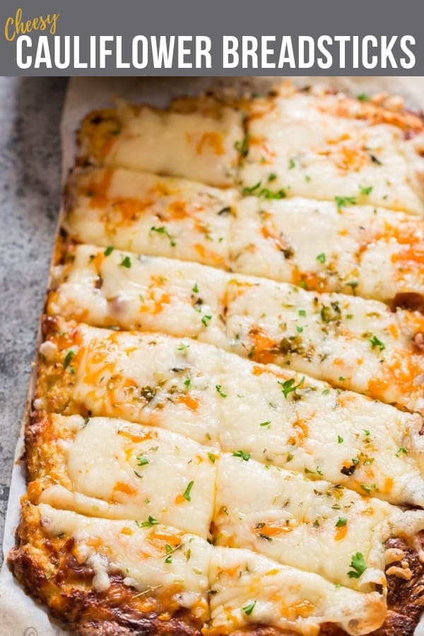 cheesy cauliflower breadsticks served with spicy marinara sauce with text overlay