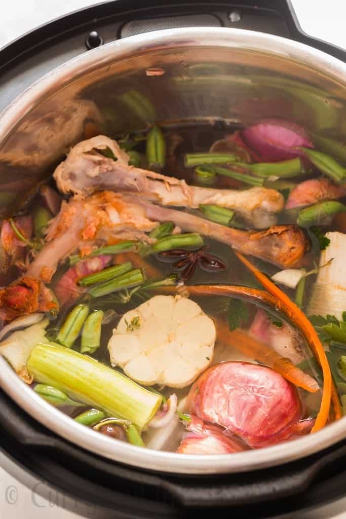 instant pot bone broth in the making, chicken bones, vegetables scraped added inside the pot