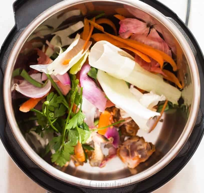 instant pot bone broth in the making, chicken bones, vegetables scraped added inside the pot