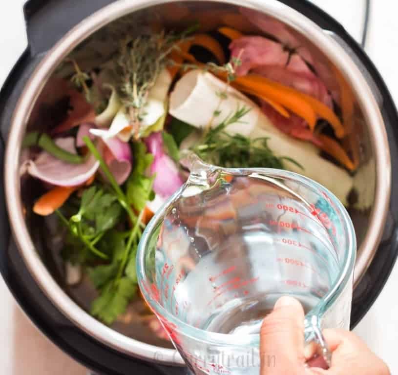 instant pot bone broth in the making, chicken bones, vegetables scraped added inside the pot