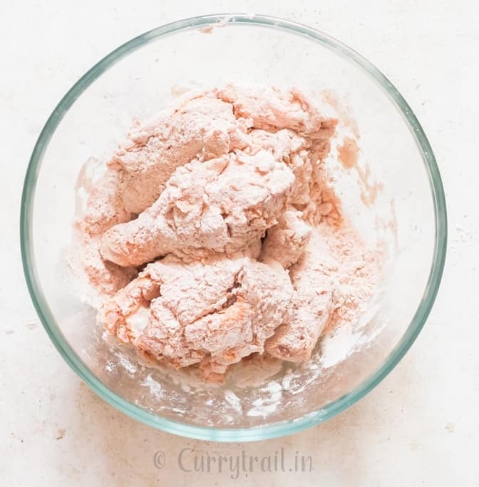 chicken coated in flour mix before frying.