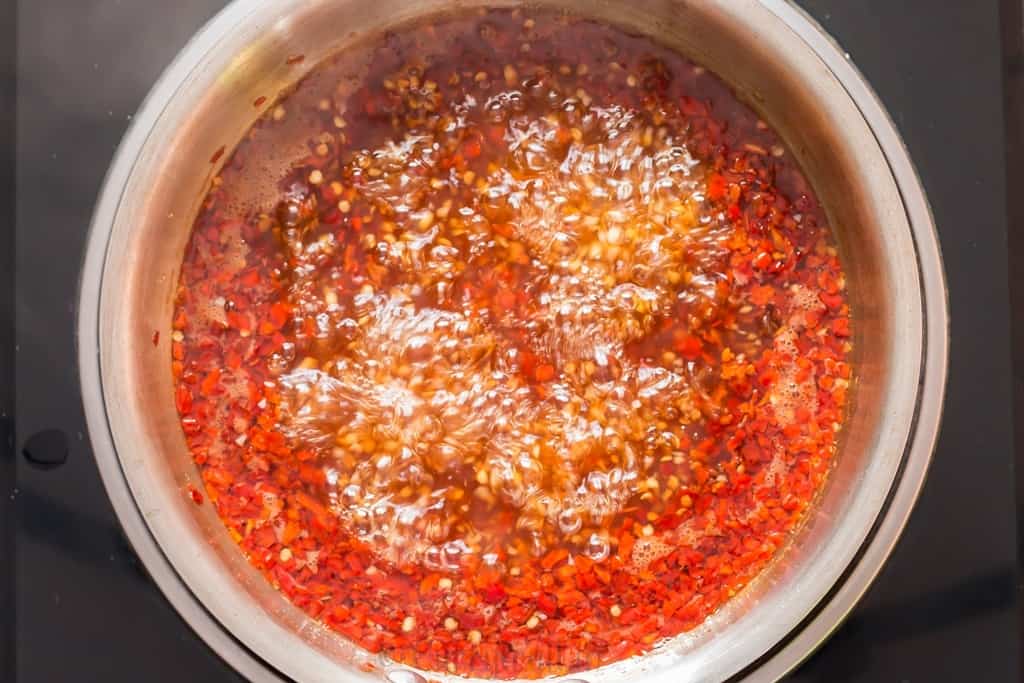 cooking homemade spicy sweet chili sauce in pan