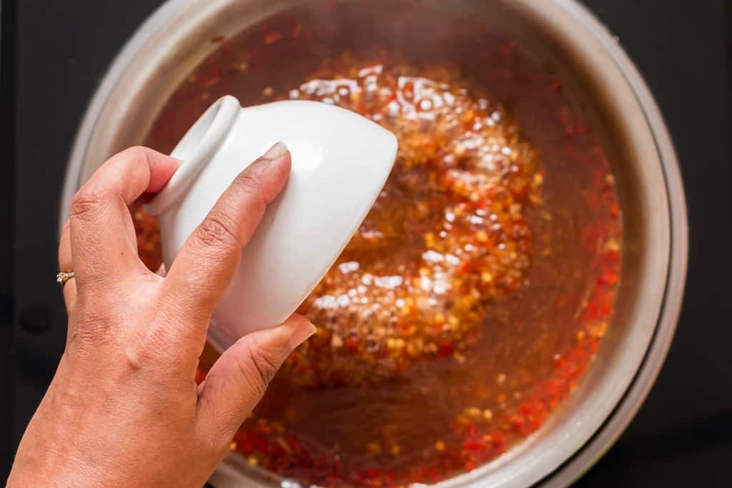 cooking homemade spicy sweet chili sauce in pan