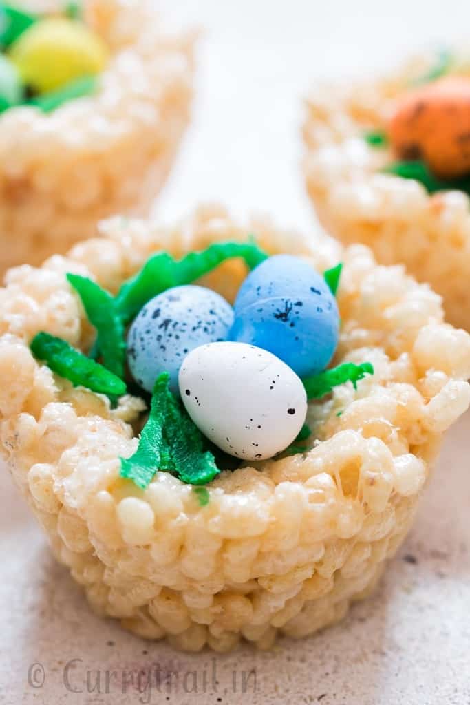 Easter Rice Krispie Treats Birds Nests topped with colored coconut flakes and Easter eggs