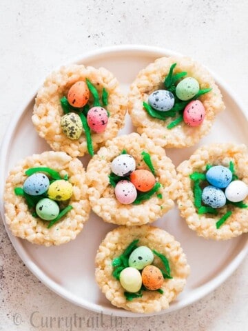 Easter Rice Krispie Treats Birds Nests topped with colored coconut flakes and Easter eggs