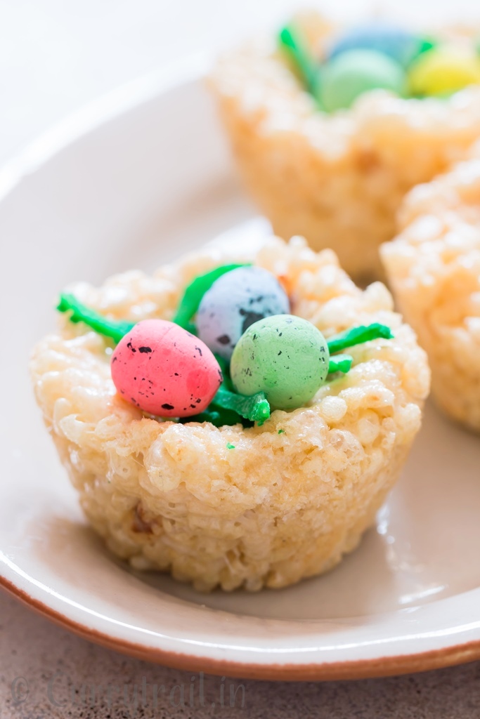 Easter Rice Krispie Treats Birds Nests topped with colored coconut flakes and Easter eggs