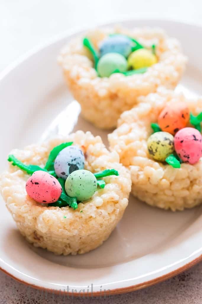 Easter Rice Krispie Treats Birds Nests topped with colored coconut flakes and Easter eggs