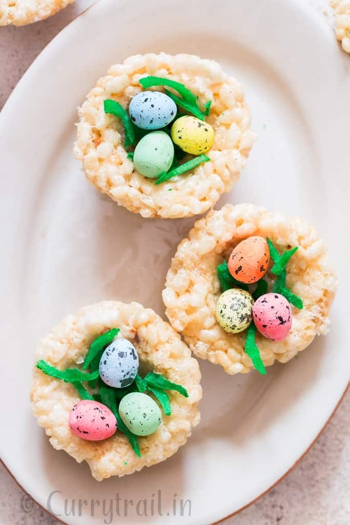 Easter Rice Krispie Treats Birds Nests topped with colored coconut flakes and Easter eggs