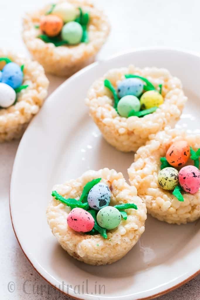 Easter Rice Krispie Treats Birds Nests topped with colored coconut flakes and Easter eggs