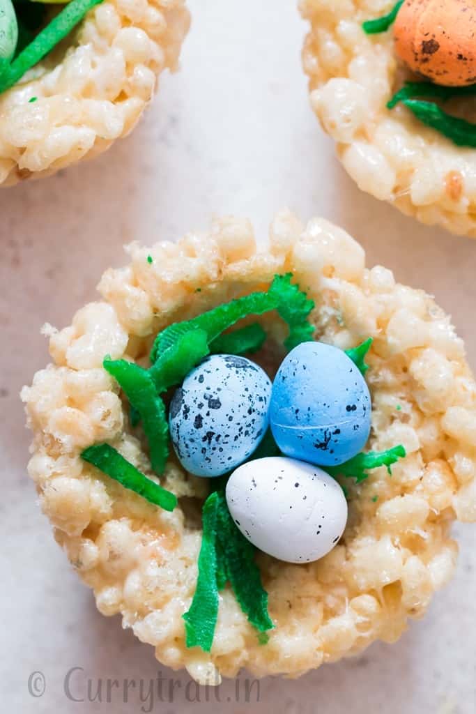 Easter Rice Krispie Treats Birds Nests topped with colored coconut flakes and Easter eggs