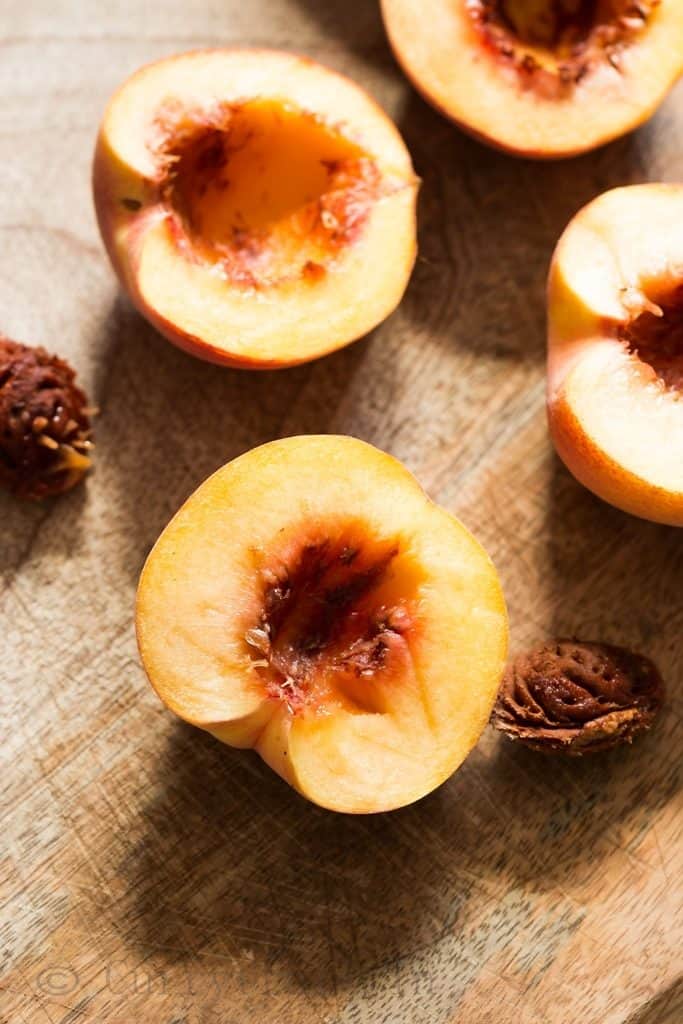 peaches cut into half, getting ready for grilled peaches recipe