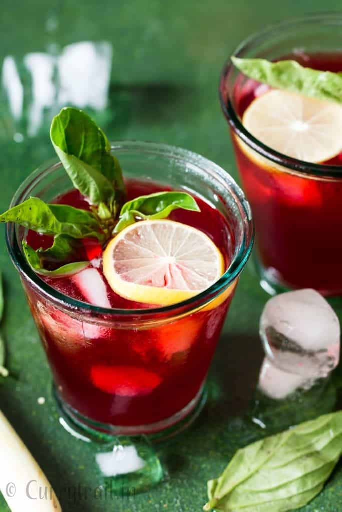 refreshing hibiscus iced tea served in glasses with basil and lemon