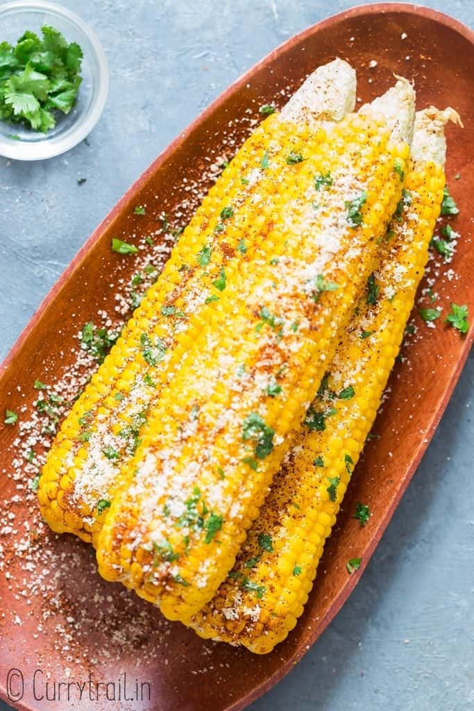3 boiled instant pot corn on the cob on wooden plate