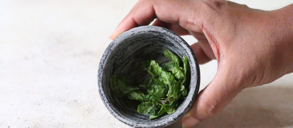 muddle mint leaves in a pestle.