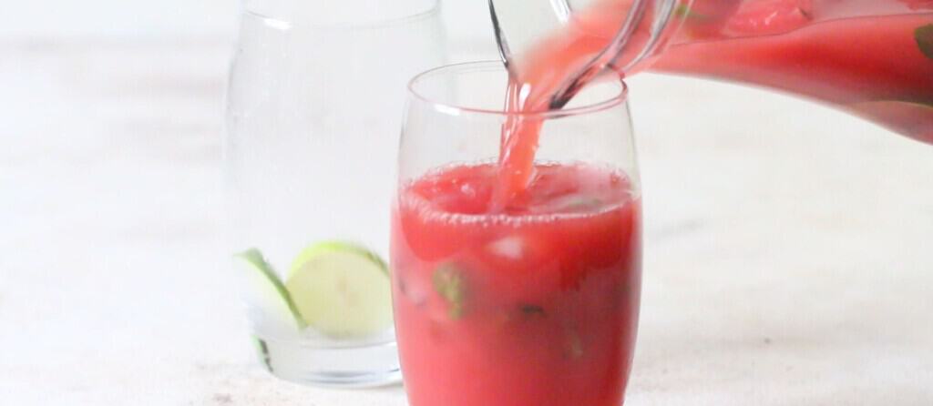 pouring watermelon mojito in glass.