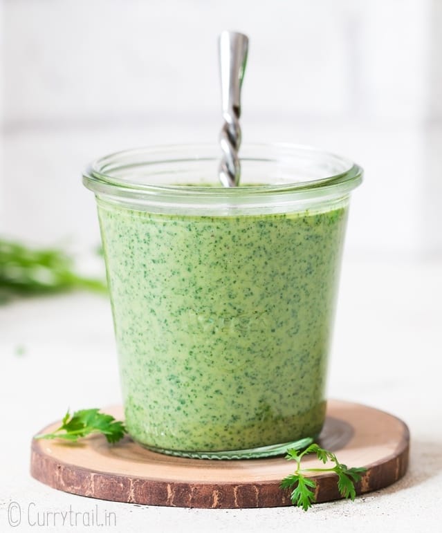 cilantro sauce served in glass weck jar with spoon in it