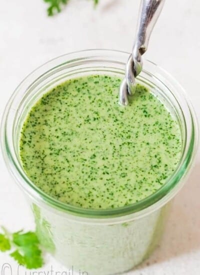 creamy cilantro sauce in glass jar with fancy spoon