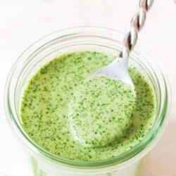 spooning cilantro lime sauce from a glass jar.