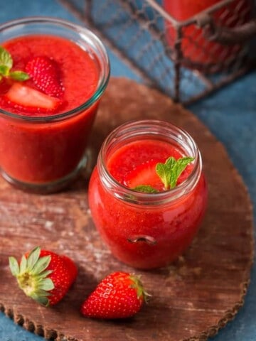 healthy cold summer strawberry gazpacho soup served in glass jars