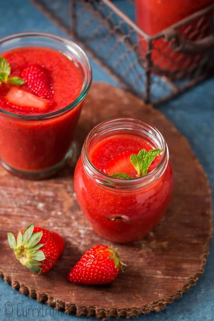 healthy cold summer strawberry gazpacho soup served in glass jars