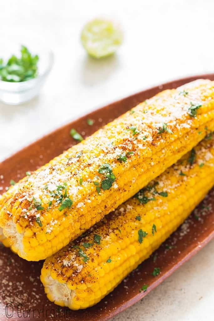 3 instant pot corn on the cob arranged on wooden plate