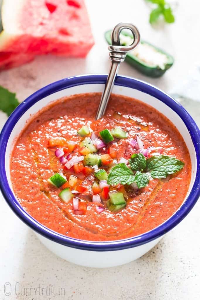 spicy watermelon gazpacho served cold in white bowl with spoon in it