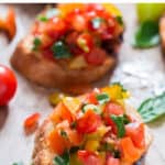 bruschetta with fresh tomatoes on wooden board with text