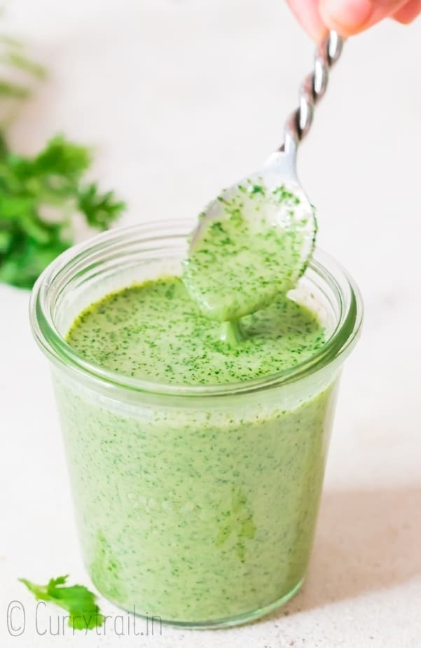 cilantro sauce in glass jar with fancy spoon