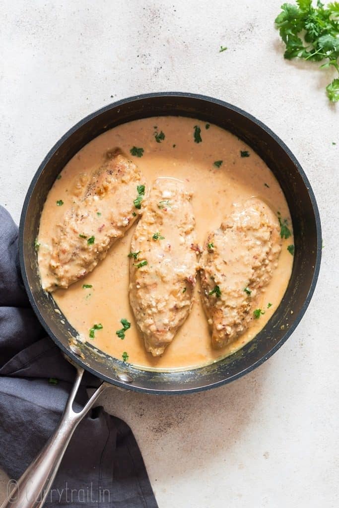 cooking skillet with three chicken breasts in creamy chipotle chicken dish