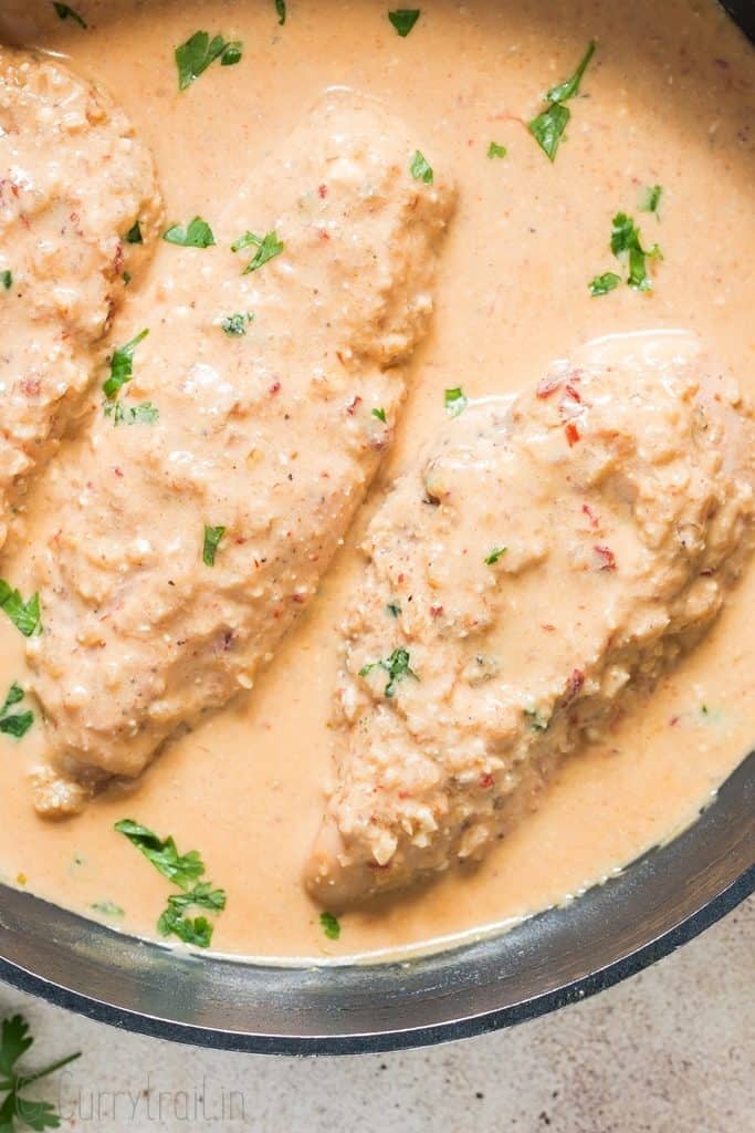 three chicken breasts in creamy chipotle chicken dish in cooking skillet