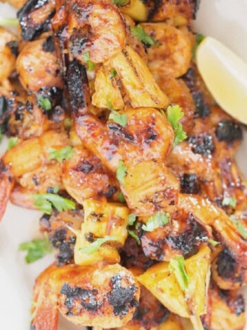 pineapple and shrimp skewers with teriyaki sauce.