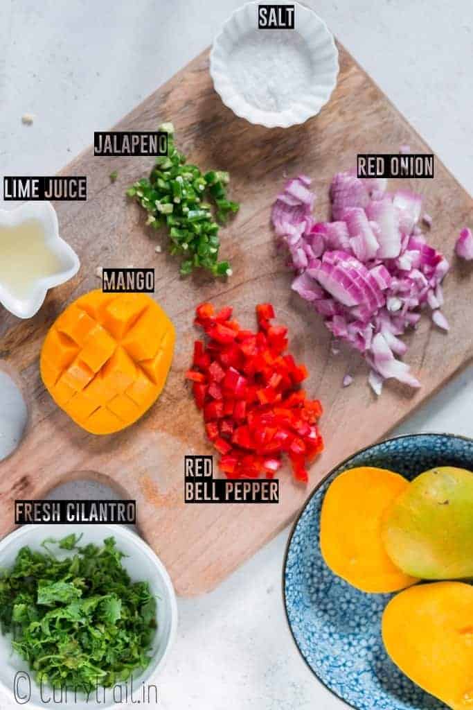 all ingredients for mango salsa recipe on wooden board