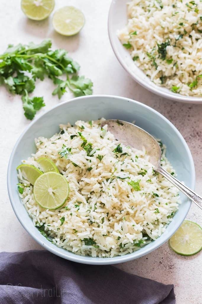two bowls of lime and cilantro rice with lime slices