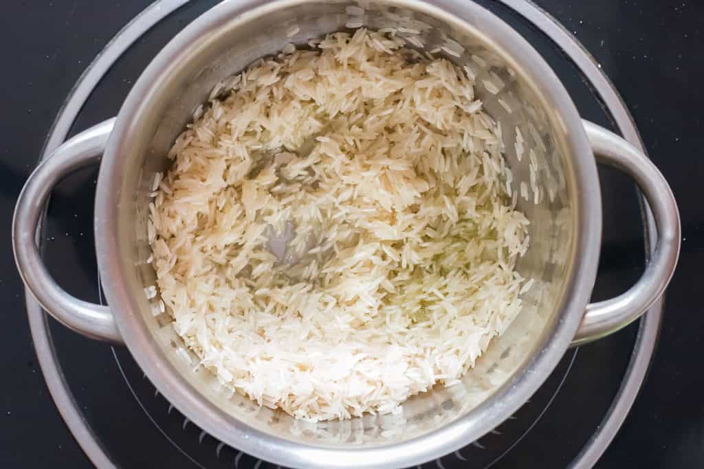 sautéing rice in oil in a pan.