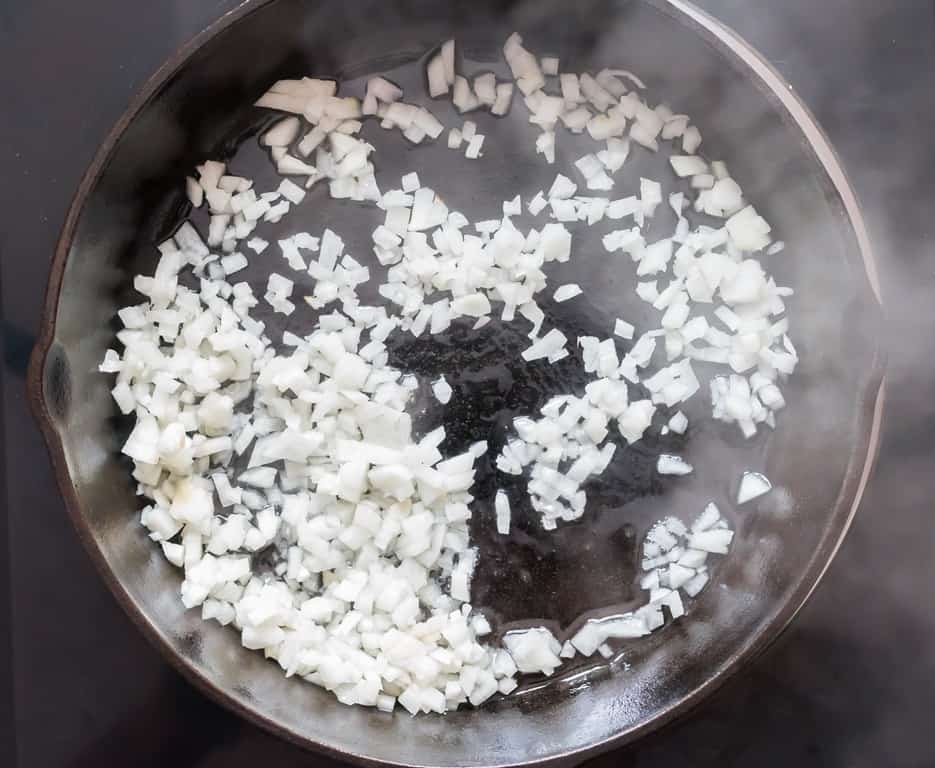 white onions sauteed in oil in cast iron pan